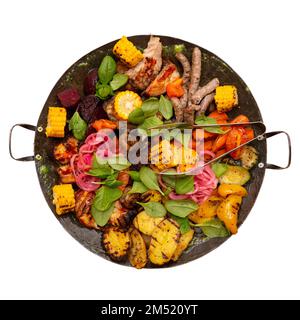 Gemischtes gebratenes Gemüse und Fleisch, in einem Wok gebraten. Gebratener Mais, Karotten, Kartoffeln, Rüben, Pilze, Zwiebeln, Tomaten und Paprika. Fleischwürste und P. Stockfoto