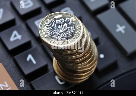 EIN-PFUND-MÜNZEN-STAPEL AUF DEM RECHNER FÜR LEBENSHALTUNGSKOSTEN KRISEN-RENTEN EINKOMMEN INFLATION HAUSHALTSBUDGETS ETC. UK Stockfoto