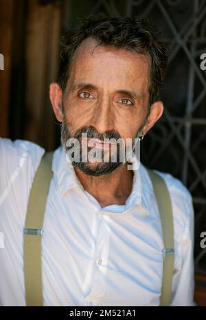 Ein vertikales Porträt eines hispanischen Mannes mittleren Alters, der ein weißes Hemd trägt Stockfoto