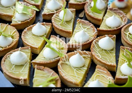 Stockbild eines großen Tabletts mit schicken Törtchen, serviert in einem Buffet im Freien. Stockfoto