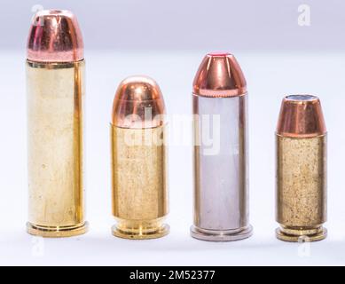 Vier Kugeln unterschiedlichen Kalibers, eine 454 casull, 44 Special, 45 acp und eine 40 Kaliber auf weißem Hintergrund Stockfoto