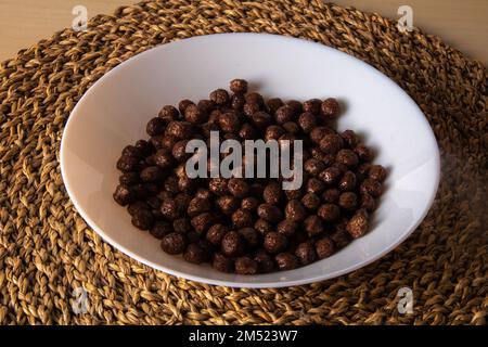 Foto von getrockneten Schokoladen-Cornflakes-Bällen, die auf einem Teller liegen Stockfoto