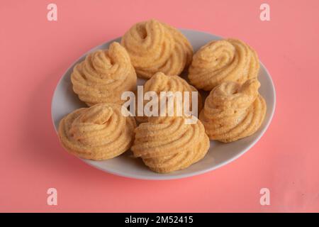 Foto von Kuchen auf einem Teller auf pinkfarbenem Hintergrund Stockfoto