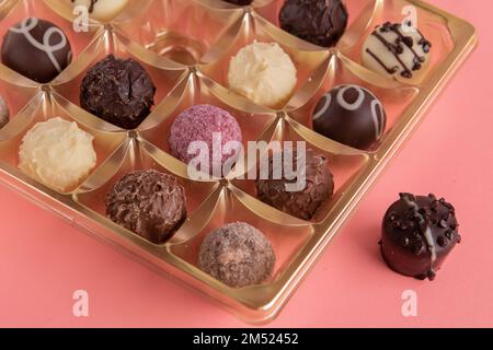 Runde Fotoschokolade in einer Schachtel auf pinkfarbenem Hintergrund Stockfoto