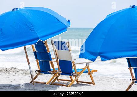 Blaue Strandliegen und Sonnenschirme in Myrtle Beach, South Carolina, USA. Stockfoto