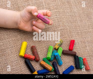 Verwendete Farbkreiden und ein Kleinkind Hand hält ein Stockfoto