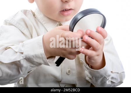 Baby mit einer Lupe in Hand auf weißem Hintergrund Stockfoto