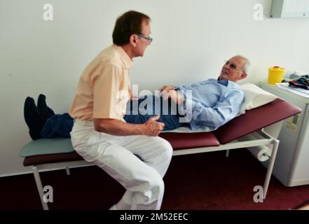 Dieser Internist im Zentrum einer größeren Stadt arbeitet hauptsächlich als Hausarzt. Das Foto zeigt: Untersuchung des Abdomens, Deutschland Stockfoto