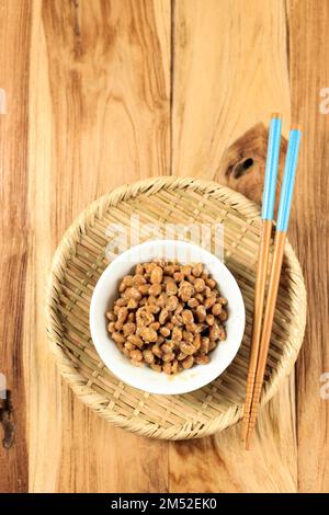 Blick von oben auf japanisches Natto auf Holztisch. Natto ist eine in Japan beliebte, fermentierte Sojabohne Stockfoto