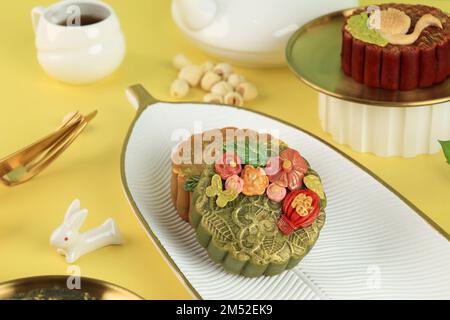 Grüner Tee-Mondkuchen mit goldenem Staub auf gelbem Hintergrund. Konzept für das Herbstfest mit Kopierbereich für Text. Chinesisches Zeichen bedeutet „Fu“ für Stockfoto