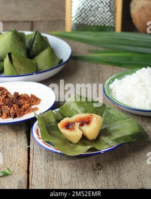 Süßer gefüllter Teig in Pyramidenform oder Kanom Tian Kaew auf einem Holztisch, traditionelles thailändisches Dessert zum chinesischen Neujahr. Stockfoto