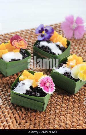 Mini Black Sticky Mango Reis auf Holztisch, thailändisches Dessert Stockfoto