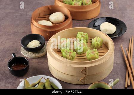 Gemüse-Shumai mit grüner Hautfarbe, gedämpfter Dim Sum Dumpling auf Bambus-Dampfgarer. Bereich Kopieren Stockfoto