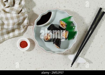 Top View Mini-Sushi mit Ei- und Rindfleischcreme, serviert mit Sojasauce und Chiliflocken Stockfoto