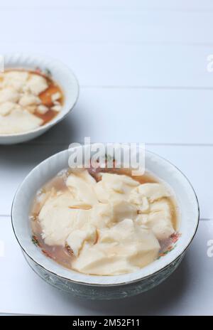 Douhua Tahwa, taiwanesischer Tofu Dessertpudding oder Sojabohnen-Soja-Pudding mit Ingwer und Palmenzuckersirup. Stockfoto