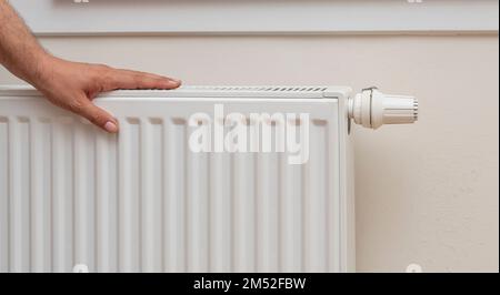 Eine menschliche Hand, die die Temperatur eines Kühlers prüft Stockfoto