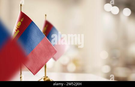 Kleine Flaggen der Mongolei auf abstraktem, verschwommenem Hintergrund. Stockfoto