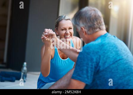 Teamwork macht den Traum wahr. Ein reifes und motiviertes Paar, das sich am Ende eines intensiven Workouts gegenseitig gratuliert. Stockfoto