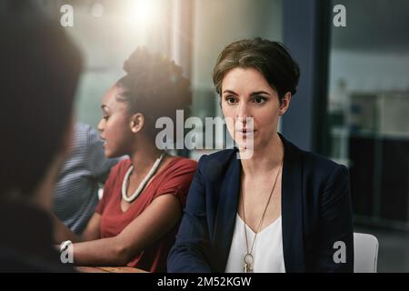 Darauf fokussiert, gemeinsam an die Spitze zu kommen. Eine Gruppe von Designern, die eine Diskussion in einem Büro führen. Stockfoto