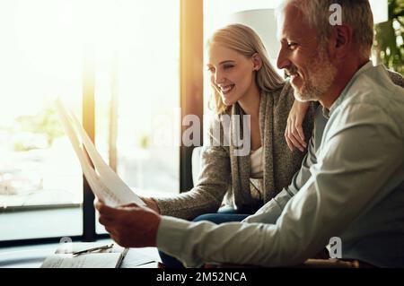 Nur ein weiterer Tag zu Hause. Ein Paar, das zu Hause zusammen seinen Papierkram durchsucht. Stockfoto