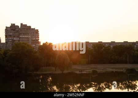 Mehrstöckiges Gebäude vor dem Hintergrund des Sonnenuntergangs am Abend in der Stadt dnipro in der ukraine im Herbst 2020 Stockfoto