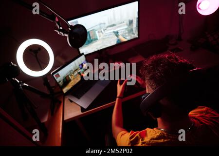 Blick von oben auf einen Spieler, der in einem Raum sitzt und alleine spielt Stockfoto