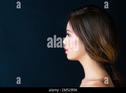 Rächen Sie sich. Eine schöne junge Frau, die vor einem dunklen Hintergrund posiert. Stockfoto