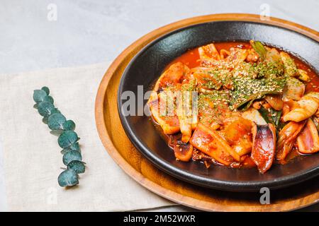 Koreanisches Essen gebratener Tintenfisch, Ojingeobokkeum : Tintenfisch mit Zwiebeln, Karotten und Kohl in einer würzigen Mischung aus Gochujang und rotem Chilipulver gebraten Stockfoto