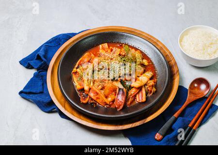 Koreanisches Essen gebratener Tintenfisch, Ojingeobokkeum : Tintenfisch mit Zwiebeln, Karotten und Kohl in einer würzigen Mischung aus Gochujang und rotem Chilipulver gebraten Stockfoto