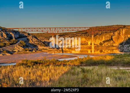 US-90 Highway Bridge, erbaut 1957, über dem Pecos River in der Nähe des Zusammenflusses Rio Grande, Kalksteinklippen, Sonnenuntergang, Texas, USA Stockfoto