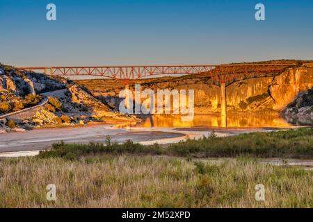 US-90 Highway Bridge, erbaut 1957, über dem Pecos River in der Nähe des Zusammenflusses Rio Grande, Kalksteinklippen, Sonnenuntergang, Texas, USA Stockfoto