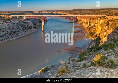 US-90 Highway Bridge, erbaut 1957, über dem Pecos River in der Nähe des Zusammenflusses Rio Grande, Kalksteinklippen, Sonnenuntergang, Texas, USA Stockfoto