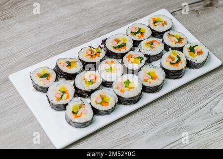 Koreanische Speisen Gimbap : Reis mit Salz und Sesamöl gewürzt und in einem Blatt gerösteter gim (getrockneter Lava) mit Spinat, Karotten und eingelegtem Käse aufgerollt Stockfoto
