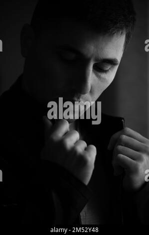 Monochromes Porträt eines Mannes mit Licht aus dem Fenster, Porträt eines jungen Mannes. Stockfoto