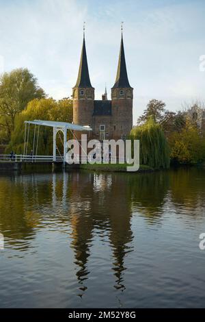 Die Türme des Osttor oder Oospoort spiegeln sich im Hauptkanal in Delft, Niederlande, wider Stockfoto