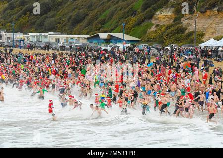 Boscombe, Dorset, Großbritannien. 25. Dezember 2022 Wetter in Großbritannien. Hunderte Weihnachtsfeier in festlichem Kostüm tauchen im Boscombe in Bournemouth in Dorset ins kalte Meer ein, um an einem kalten, bedeckten Morgen im Macmillan White Christmas Dip zu schwimmen. Bildnachweis: Graham Hunt/Alamy Live News Stockfoto