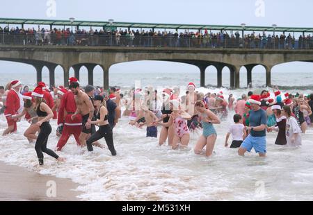 Schwimmer nehmen am Macmillan Boscombe White Christmas Dip am Boscombe Pier in Bournemouth, Dorset, Teil, um sich um Macmillan zu kümmern. Foto: Sonntag, 25. Dezember 2022. Stockfoto