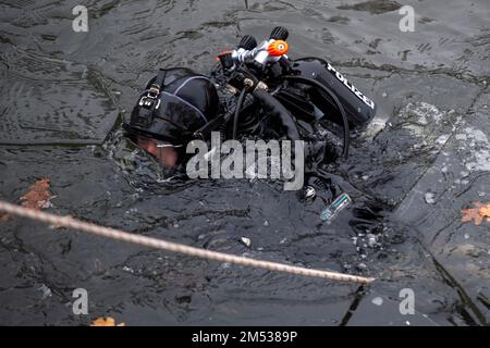 Berlin, Deutschland. 25. Dezember 2022. Ein Polizeitaucher durchsucht den Landwehrkanal. Die Suche nach Beweisen im Fall des spektakulären Juwelendiebstahls aus dem Grünen Gewölbe in Dresden geht an Weihnachten weiter. Nach Angaben der Dresdner Polizei suchen am Sonntag seit den Morgenstunden rund 20 Polizeitaucher aus verschiedenen Staaten im Landwehrkanal am Kiehlufer im Bezirk Neukölln nach Beweisstücken. Kredit: Christophe Gateau/dpa/Alamy Live News Stockfoto