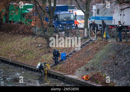 Berlin, Deutschland. 25. Dezember 2022. Ein Polizist taucht in den Landwehrkanal ein, um ihn zu durchsuchen. Die Suche nach Beweisen im Fall des spektakulären Juwelendiebstahls aus dem Grünen Gewölbe in Dresden geht an Weihnachten weiter. Nach Angaben der Dresdner Polizei suchen am Sonntag seit den Morgenstunden rund 20 Polizeitaucher aus verschiedenen Staaten im Landwehrkanal am Kiehlufer im Bezirk Neukölln nach Beweisstücken. Kredit: Christophe Gateau/dpa/Alamy Live News Stockfoto