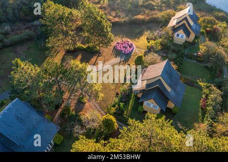 HÜTTE AM HANG. HÜTTENDORF. HAUS MIT GROSSEN FENSTERN. DER BAU DER GEHEIMNISVOLLEN HÄUSER. INFRASTRUKTUR, BINH AN VILLAGE, DALAT, VI Stockfoto