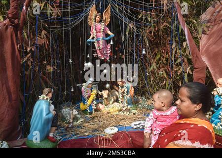 Kalkutta, West Benal, Indien. 25. Dezember 2022. Eine Frau mit einem Kleinkind sieht sich die Weihnachtsdekoration am Stadtrand von Kalkutta an. (Kreditbild: © Sudipta das/Pacific Press via ZUMA Press Wire) Kredit: ZUMA Press, Inc./Alamy Live News Stockfoto