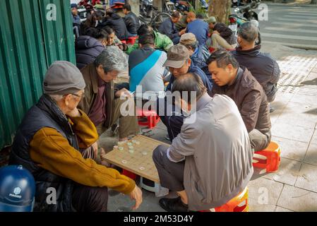 Vietnamesische Männer spielen chinesisches Schach, omn, auf dem Bürgersteig im Zentrum von Hanoi, Vietnam. Stockfoto