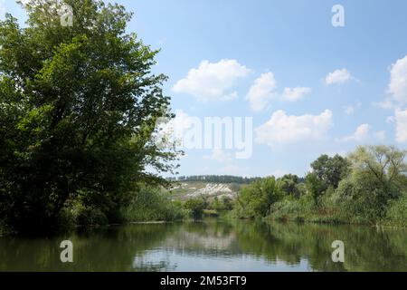 Antike multimillionäre Kreideberge auf der Steppenoberfläche der Erde. Weiße Kreideberge in einer Landschaft mit Fluss und grünen Bäumen Stockfoto