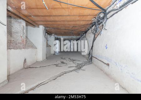 Unterirdischer Raum ohne Fenster mit vorverdrahtetem Strom mit Wellrohren in Wänden, Decken und Zementböden Stockfoto