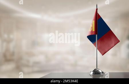 Eine kleine mongolische Flagge auf abstraktem, verschwommenem Hintergrund. Stockfoto