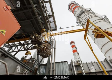 Der Motor eines Gasturbinenkompressors hängt während der Installation in einem Modul zur Stromerzeugung an einem Kran Stockfoto