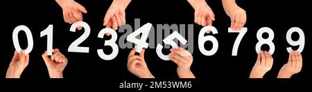 Kinderhände halten Zahlen. Ein Satz weißer Zahlen in der Hand auf schwarzem isoliertem Hintergrund. Null, eins, zwei, drei, vier, Fünf, sechs, sieben, acht Stockfoto