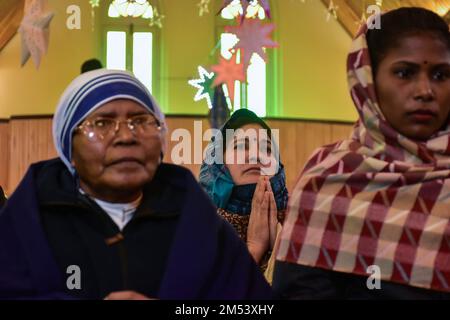 Srinagar, Indien. 25. Dezember 2022. Christliche Anhänger beten während der Weihnachtsfeier in Srinagar in der katholischen Kirche der Heiligen Familie. Die Region Kaschmir im Himalaya hat eine winzige Bevölkerung von Christen, von denen Hunderte an Weihnachten in der katholischen Kirche der Heiligen Familie zur Messe gehen und für Frieden und Wohlstand in der Region beten. Kredit: SOPA Images Limited/Alamy Live News Stockfoto