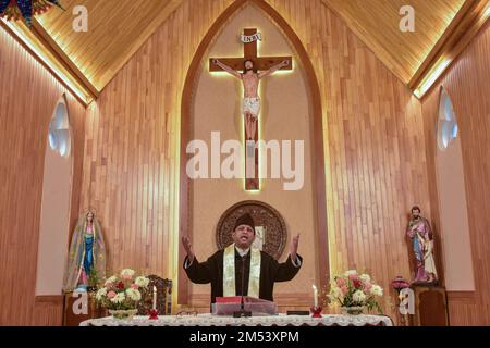 Srinagar, Indien. 25. Dezember 2022. Ein christlicher Priester betet während der Weihnachtsfeier in Srinagar in der katholischen Kirche der Heiligen Familie. Die Region Kaschmir im Himalaya hat eine winzige Bevölkerung von Christen, von denen Hunderte an Weihnachten in der katholischen Kirche der Heiligen Familie zur Messe gehen und für Frieden und Wohlstand in der Region beten. (Foto: Saqib Majeed/SOPA Images/Sipa USA) Guthaben: SIPA USA/Alamy Live News Stockfoto