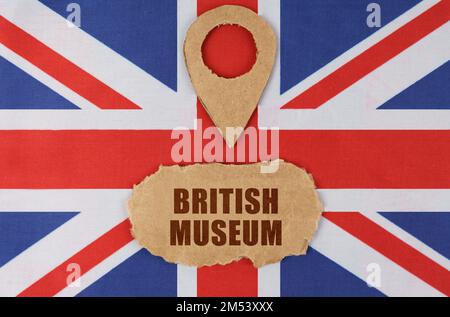 Reisekonzept. Auf der Flagge Großbritanniens befindet sich ein Symbol für Geolokation und Pappe mit der Inschrift Britisches Museum Stockfoto